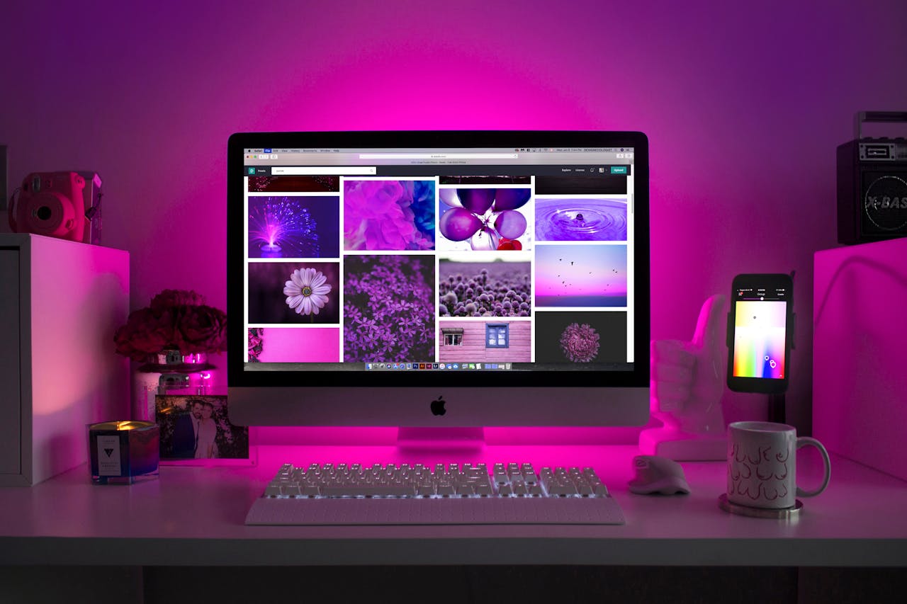 about-me-02 Modern desk setup with neon lighting and a desktop computer displaying colorful images.